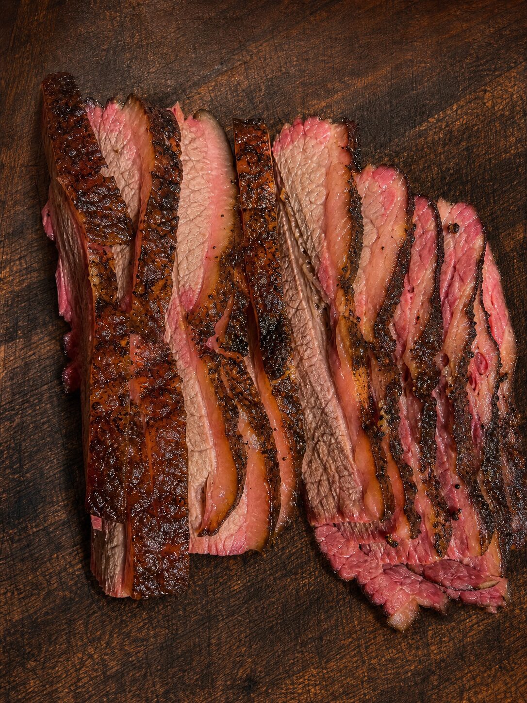 Sliced smoked brisket with dark bark and a deep pink interior